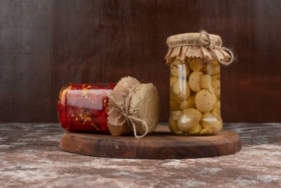 pickled-red-peppers-mushrooms-glass-jar-wooden-plate_400x267